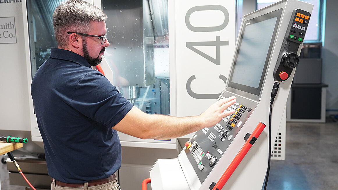 CNC Machinist Brandon Webster programs machining cycle on Smith & Co.‘s HERMLE C 400 5-axis machine.