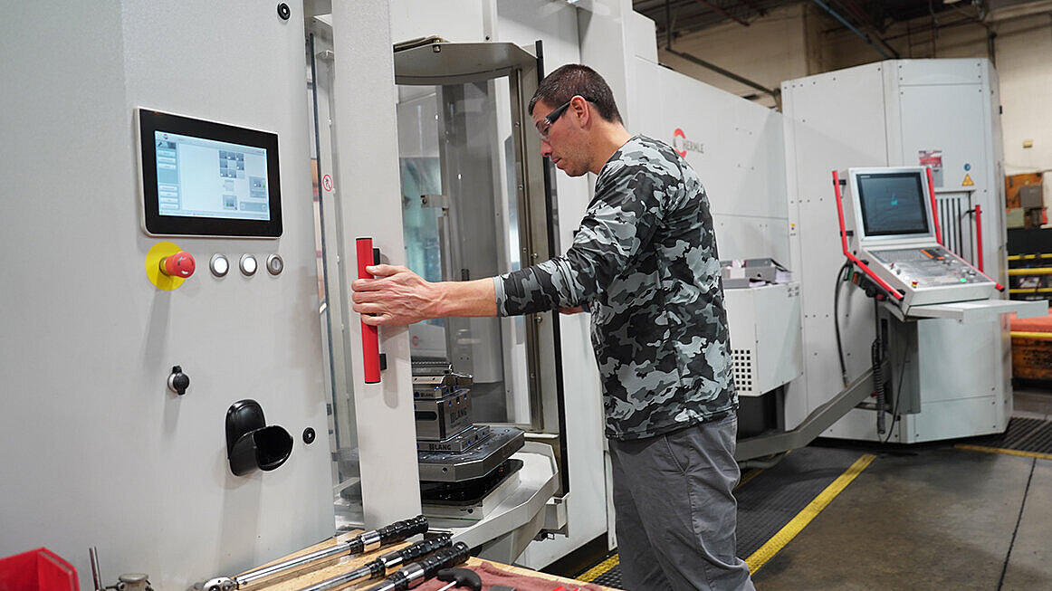 Detroit Gun Works President, Arnot Heller, inspects firearms component opening the HERMLE HS flex automation system